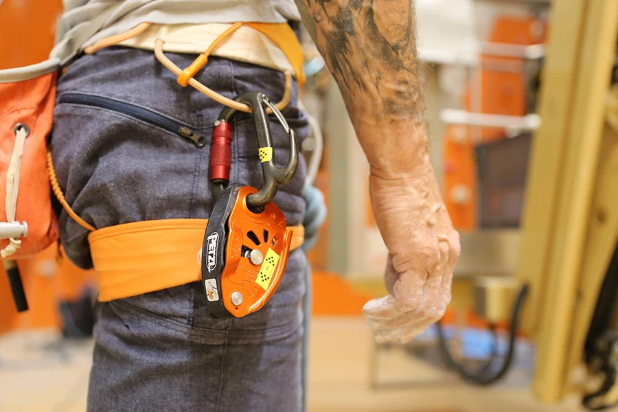 Kletterer mit Klettergurt und Sicherungsgerät